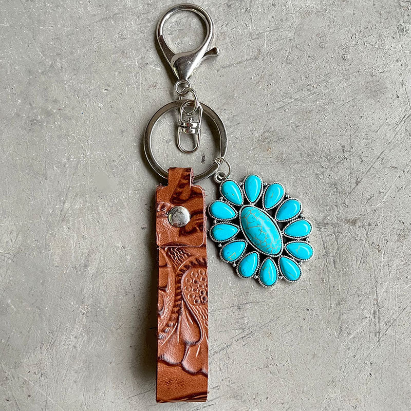 Tooled leather keychain with turquoise flower charm and silver hardware.