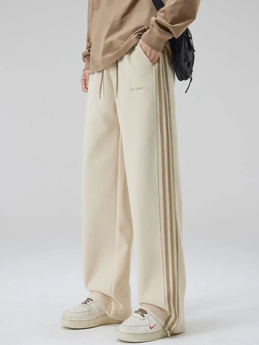 Men's khaki sweatpants with triple side stripes and drawstring waist.