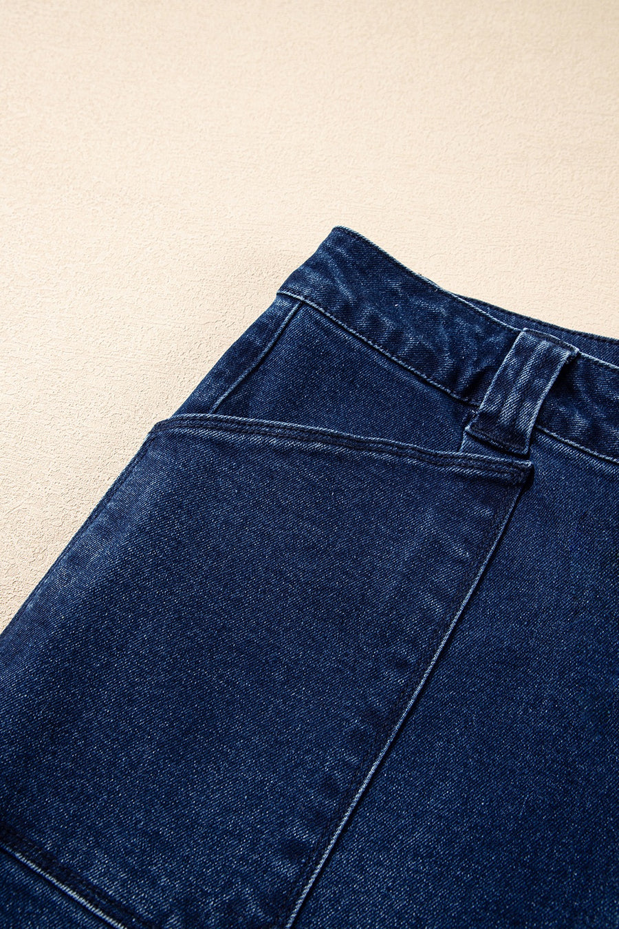 Mid-rise straight leg jeans in dark wash denim with button closure and pocket detail.