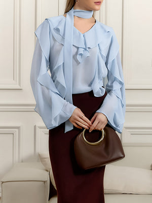 Light blue chiffon blouse with ruffle trim and V-neck, featuring long bell sleeves and a tie neck detail.