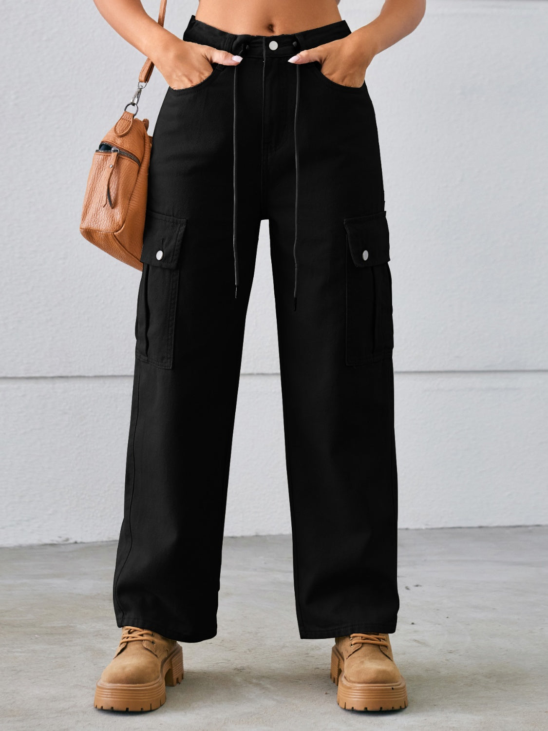 Black denim cargo pants with drawstring waist and wide legs.