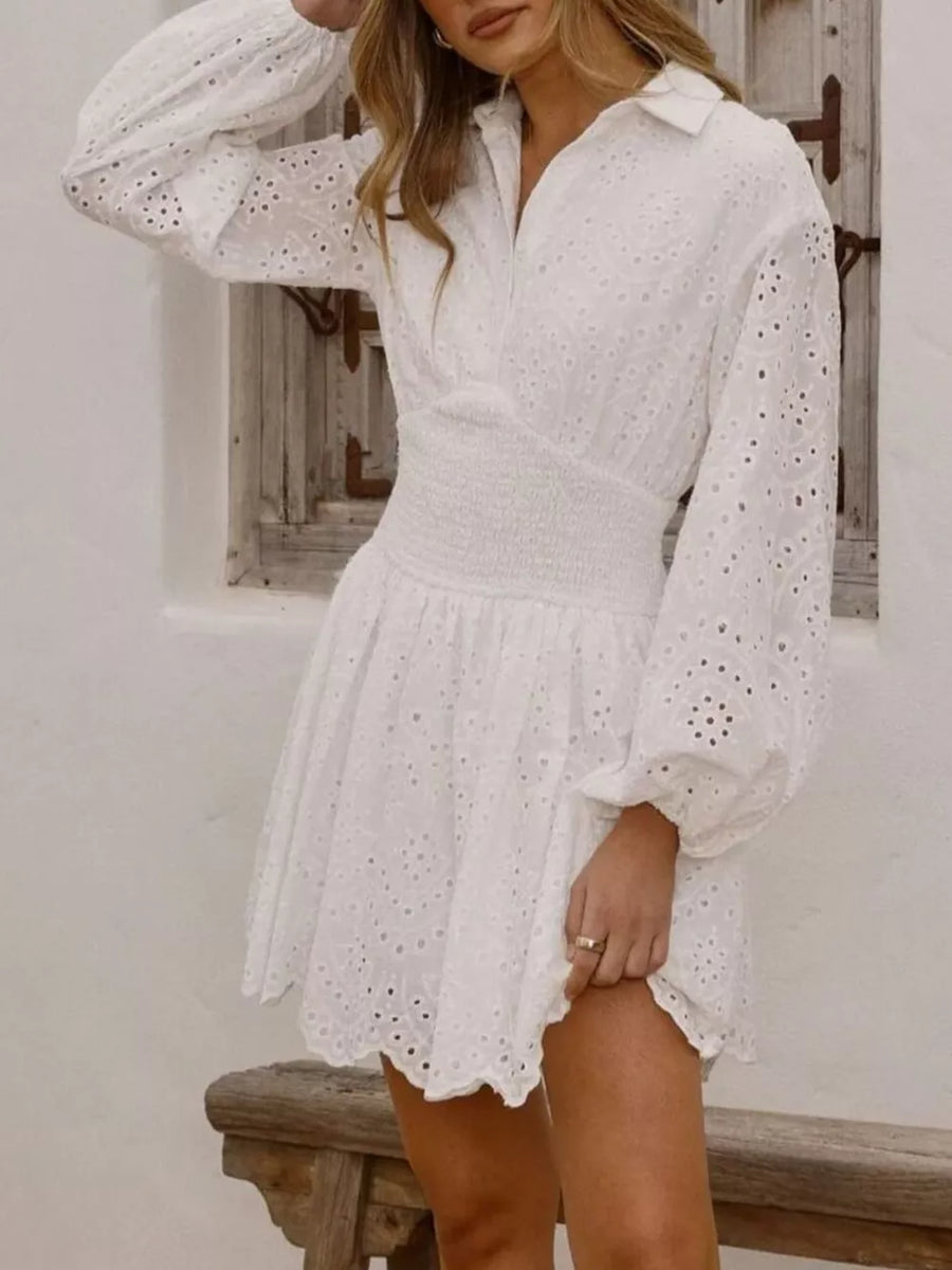White eyelet balloon sleeve mini dress with smocked waist and collared neckline.