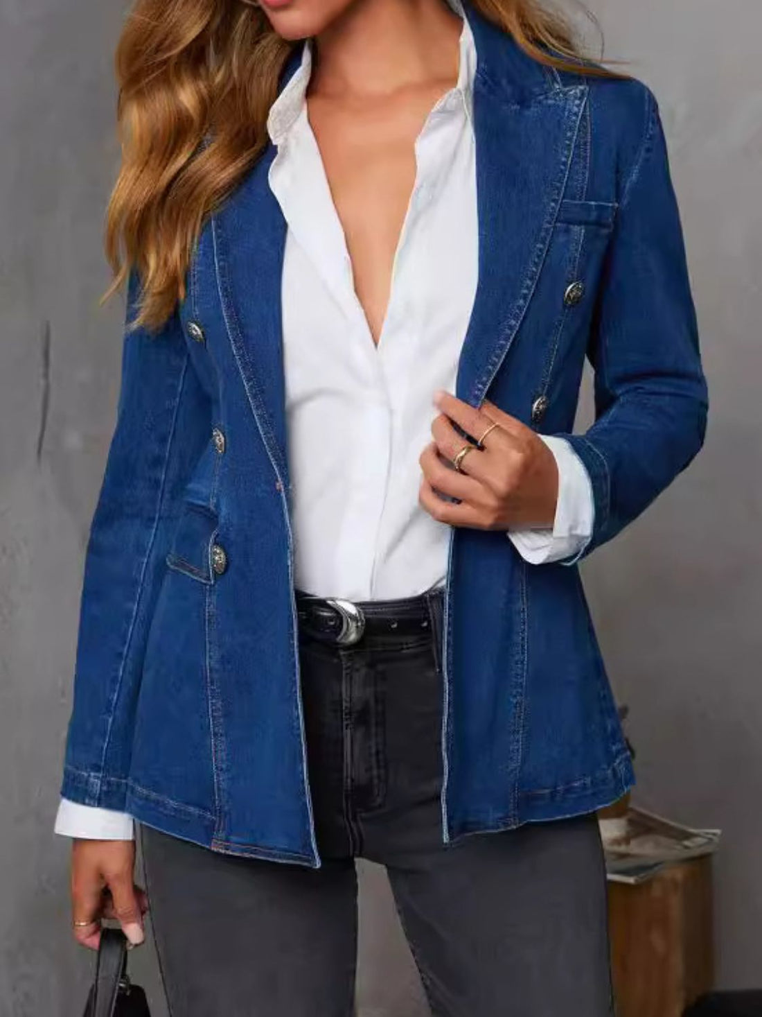 Dark denim double-breasted blazer with sculpted fit, collar, and buttoned detail.