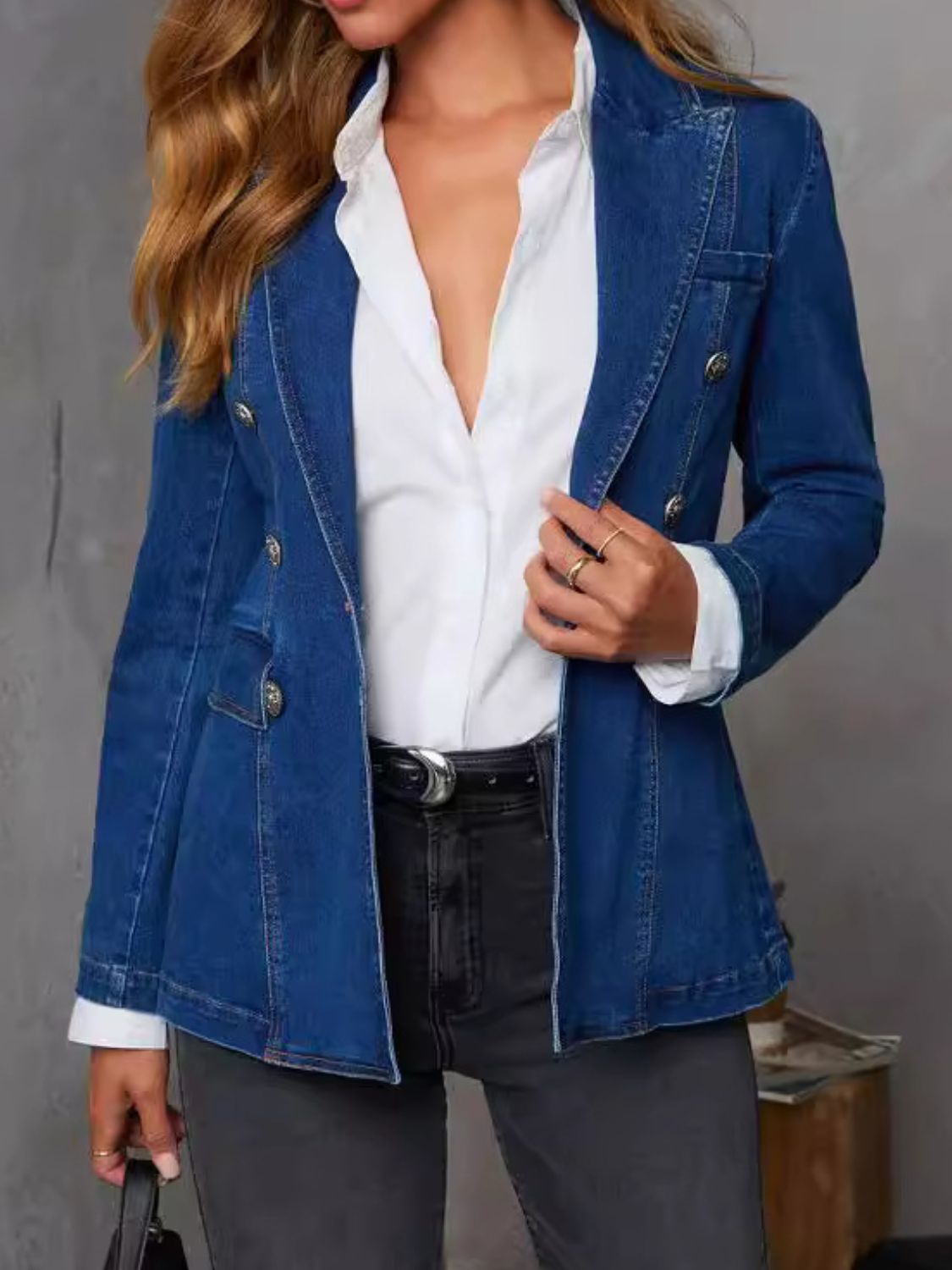 Dark denim double-breasted blazer with sculpted fit, collar, and buttoned detail.