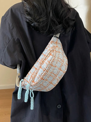 Textured tweed belt bag in pink plaid with braided light blue pulls.