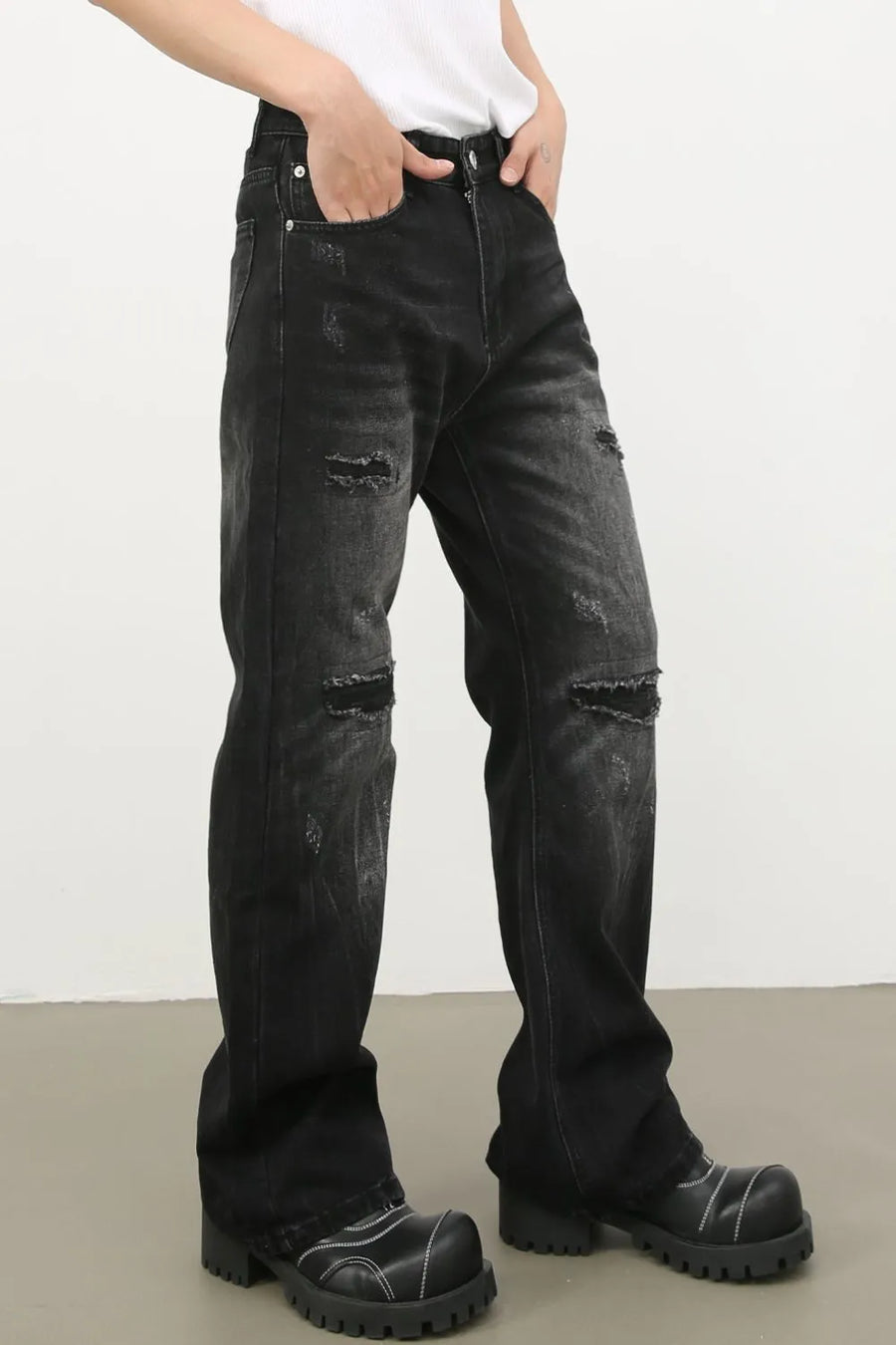 Distressed dark wash flare jeans with bleach details and ripped knees.