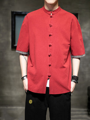 Red cotton blend short sleeve shirt with mandarin collar and frog button closure.