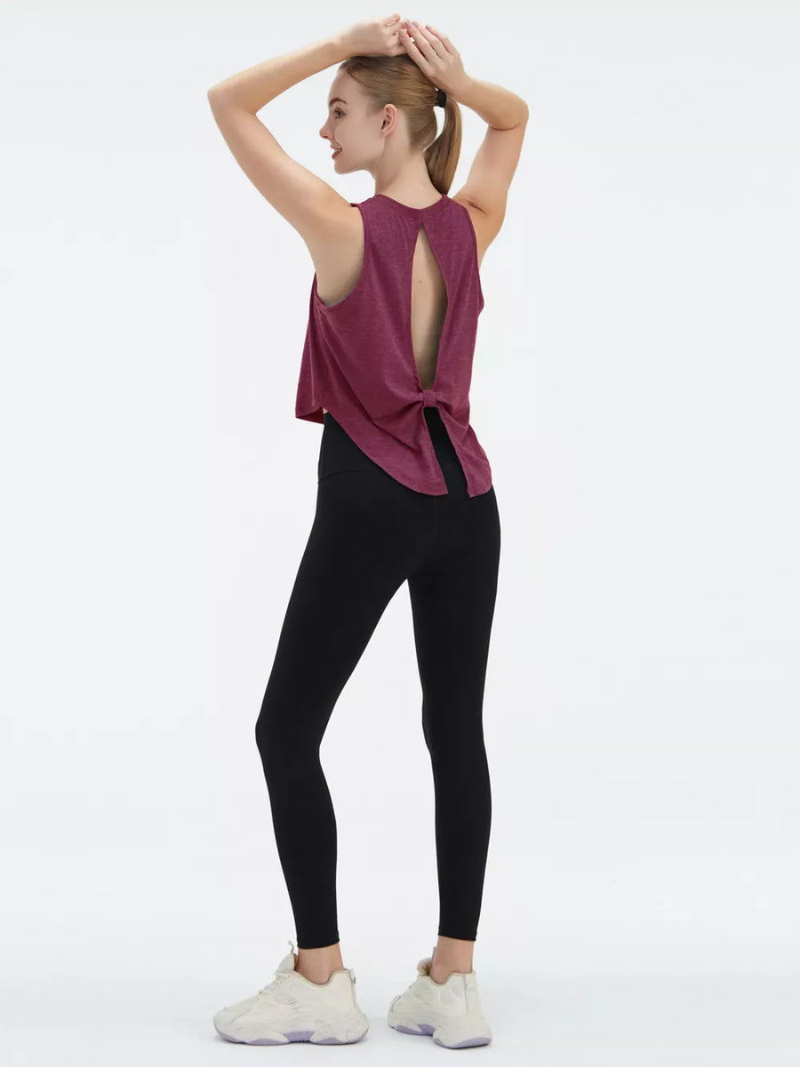 Maroon athletic tank top with open back tie detail, paired with black leggings.