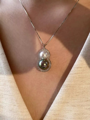 Elegant gourd pendant necklace with pearls and diamonds on a box chain.