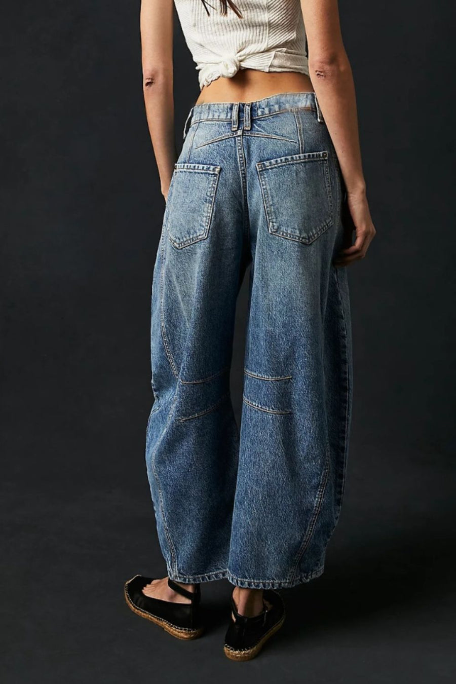 Light blue denim barrel leg jeans with paneled detail and button closure.