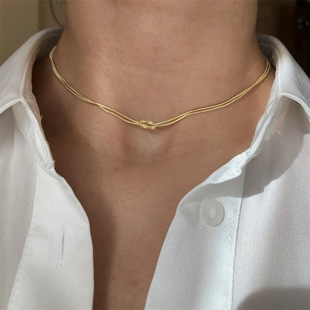 Gold serpent knot necklace with double chain detail
