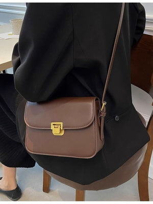 Brown shoulder bag with gold buckle flap detail