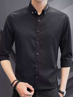 Black cotton button-down shirt with contrasting buttons and embroidered collar detail.