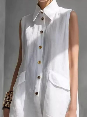 White sleeveless collared shirt dress with gold buttons and flap pockets