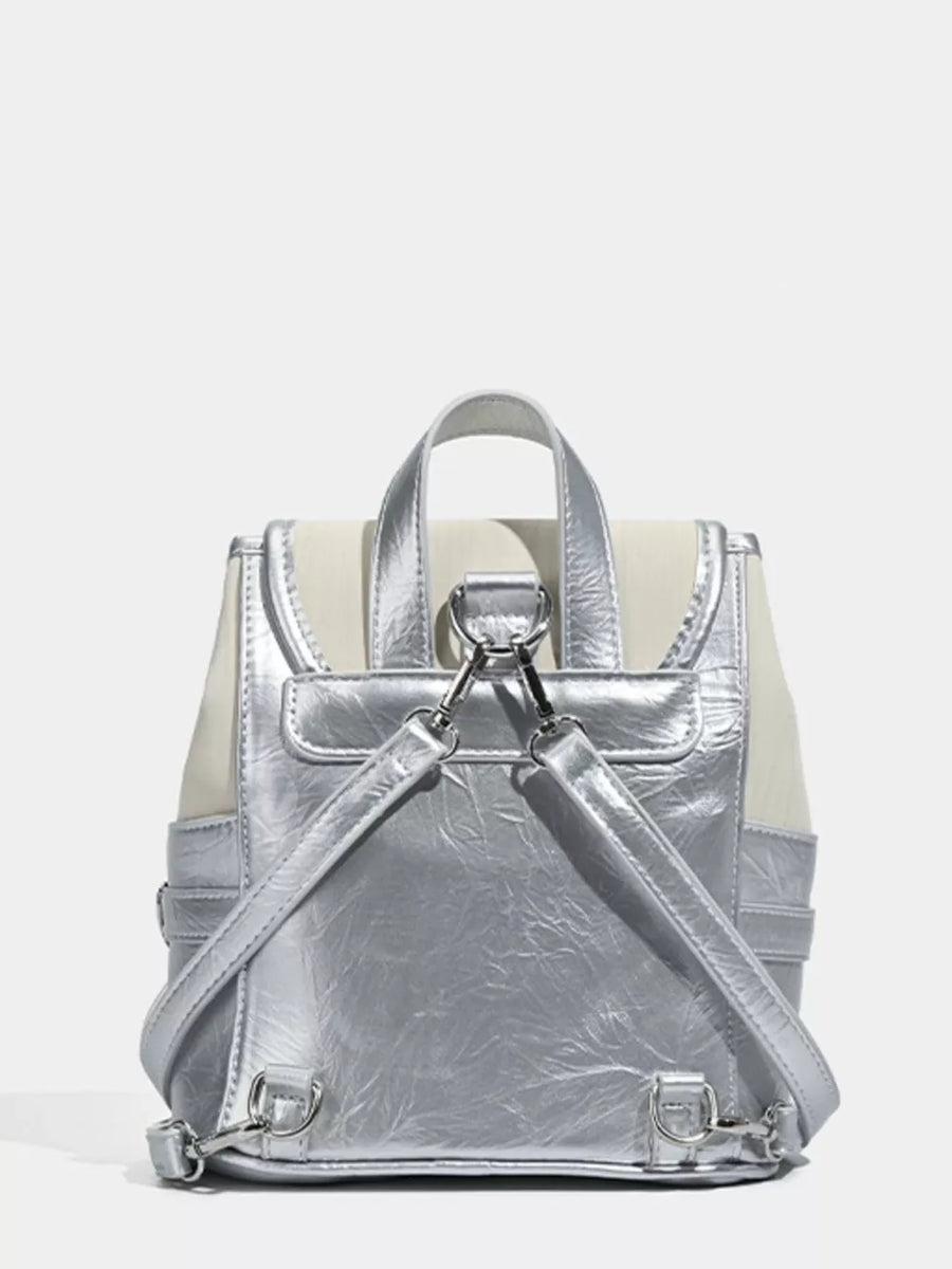Charming mini heart flap backpack in silver and cream with adjustable straps.