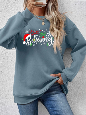 Air Force Blue long sleeve sweater with "Don't Stop Believing" graphic and Santa hat detail.