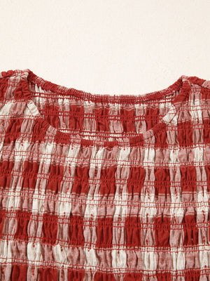 Red and white gingham smocked mini dress with a scoop neck and puff sleeves.