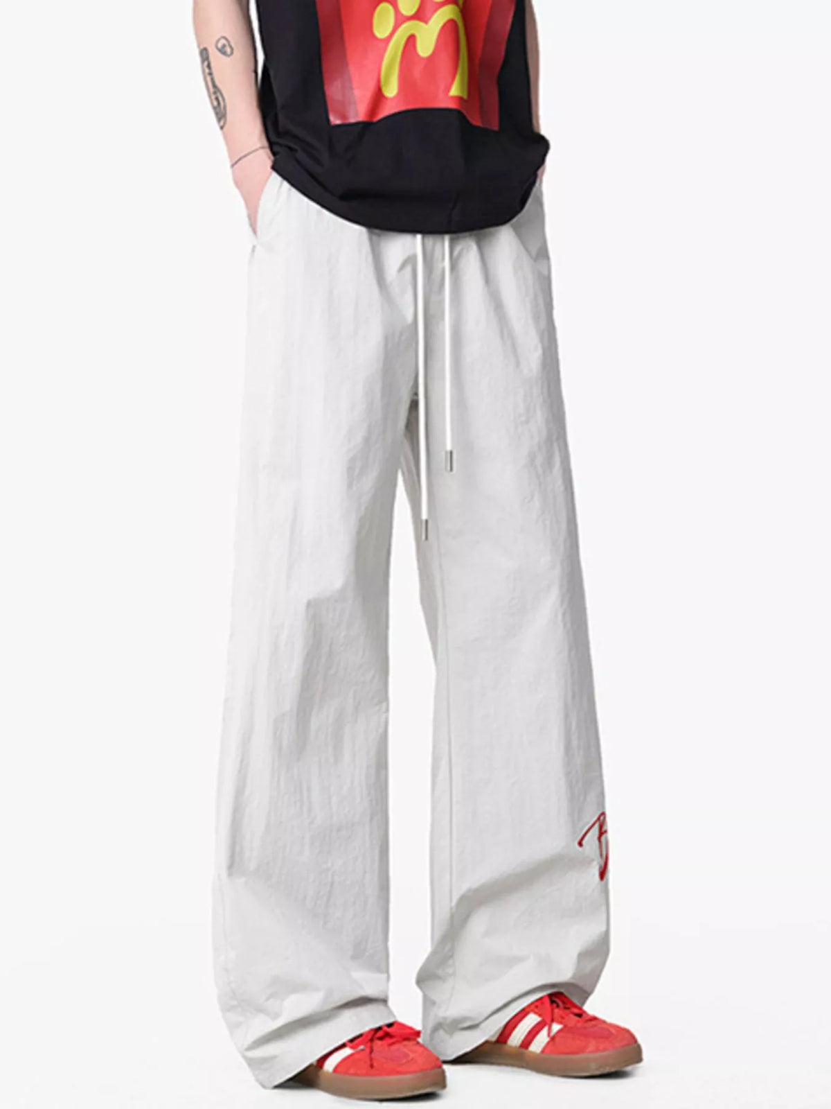 Lightweight wide-leg drawstring pants in light gray with red embroidered detail.