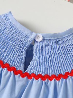 Baby blue smocked top with red ric rac trim and button closure.