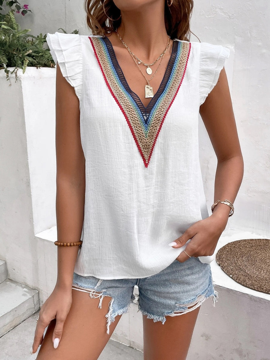 White V-neck blouse with flutter sleeves and colorful embroidered trim detail.
