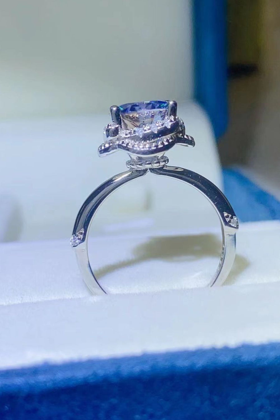 Blue moissanite halo cocktail ring with diamond accents on band.