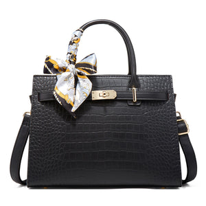 Black crocodile-embossed medium tote handbag with decorative scarf on handle.