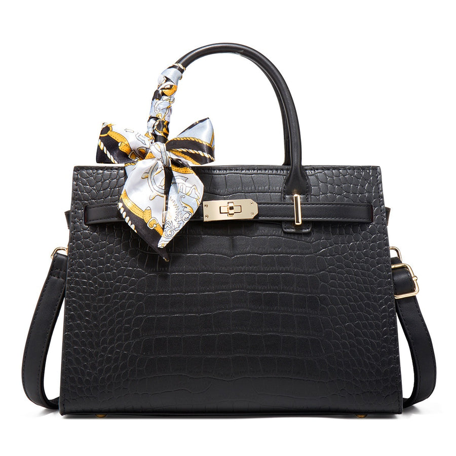 Black crocodile-embossed medium tote handbag with decorative scarf on handle.