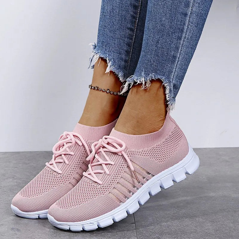 Pink knit runner sneakers with ribbed lace-up detail and white soles.