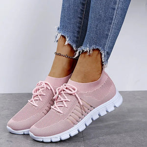 Pink knit runner sneakers with ribbed lace-up detail and white soles.