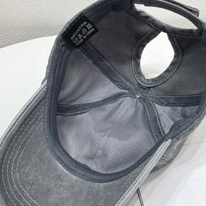 Gray cotton baseball cap with ponytail hole and 100% cotton tag.