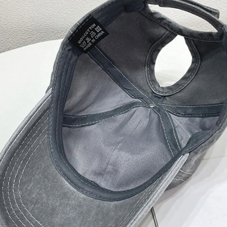 Gray cotton baseball cap with ponytail hole and 100% cotton tag.
