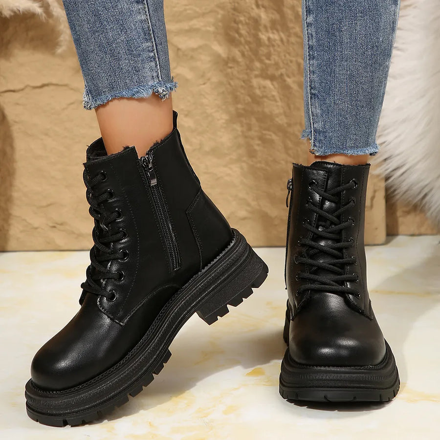Black combat boots with side zip detail and lace-up front on a platform sole.