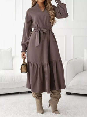 Coffee brown midi dress with ruffle hem, long sleeves, tie waist, and mock neck.