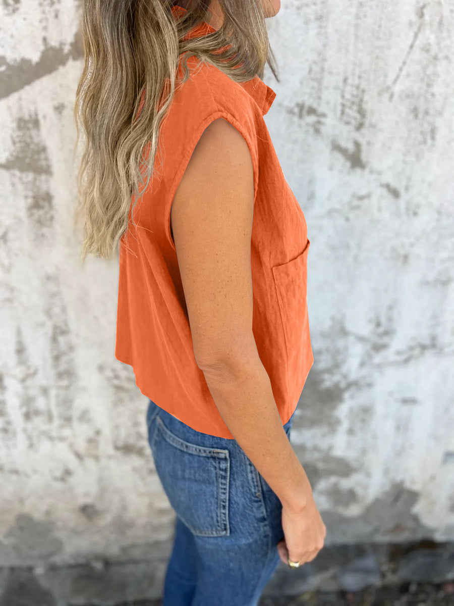 Orange button-down cap sleeve cropped shirt with a pocket.