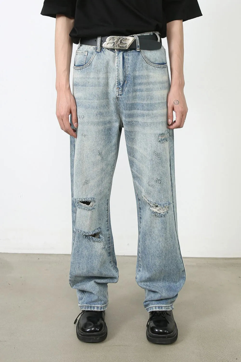 Baggy ripped denim jeans in medium wash with distressed details and a relaxed fit.