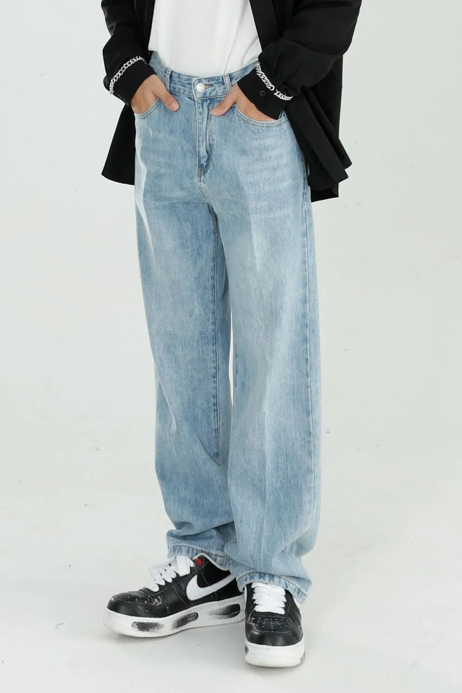 Relaxed fit light wash denim jeans with a wide leg, styled casually.