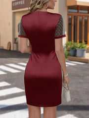 Wine red satin dress with ruched detail and sheer polka dot sleeves.