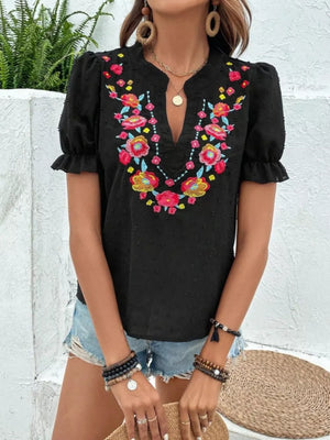 Black embroidered puff sleeve blouse with colorful floral neckline detail.