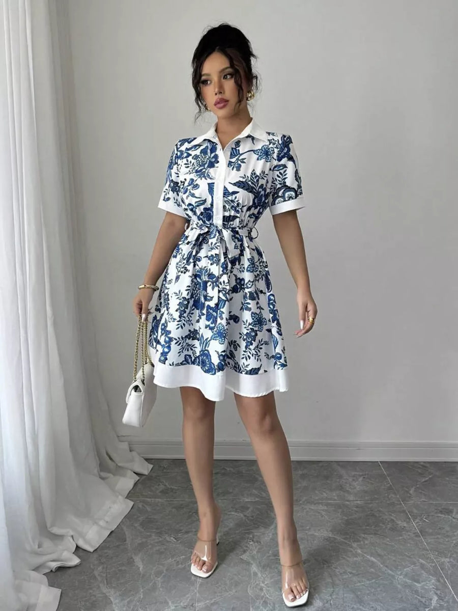 Floral print mini dress in indigo with short sleeves, collared neckline, and tie belt.