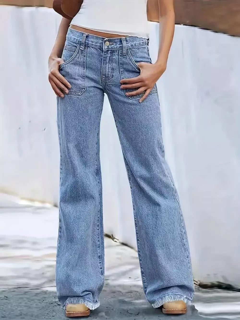 Tailored high-waisted wide-leg jeans in light wash denim with button fly and cargo pockets.