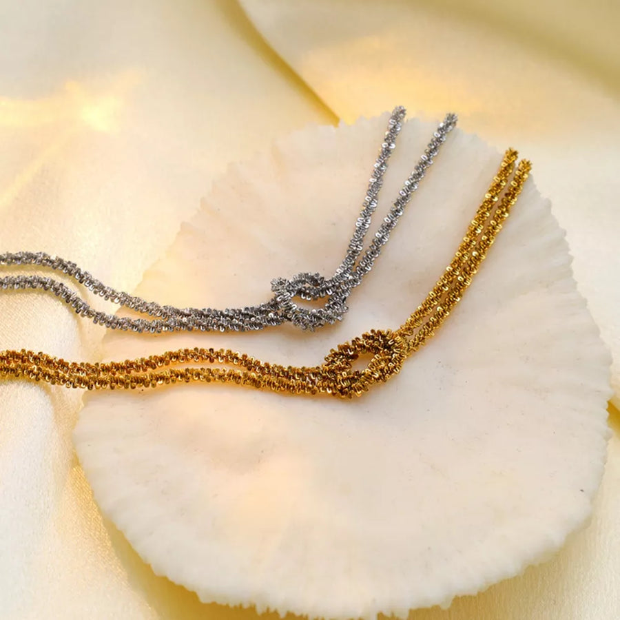 bracelet in gold featuring twisted chain and chain fit