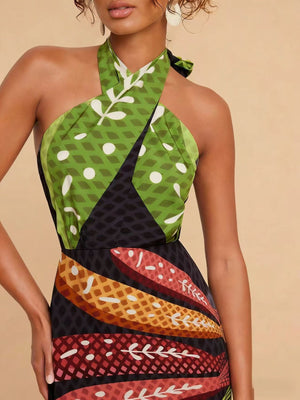Tropical print halter neck midi dress with green, black, and colorful leaf patterns.