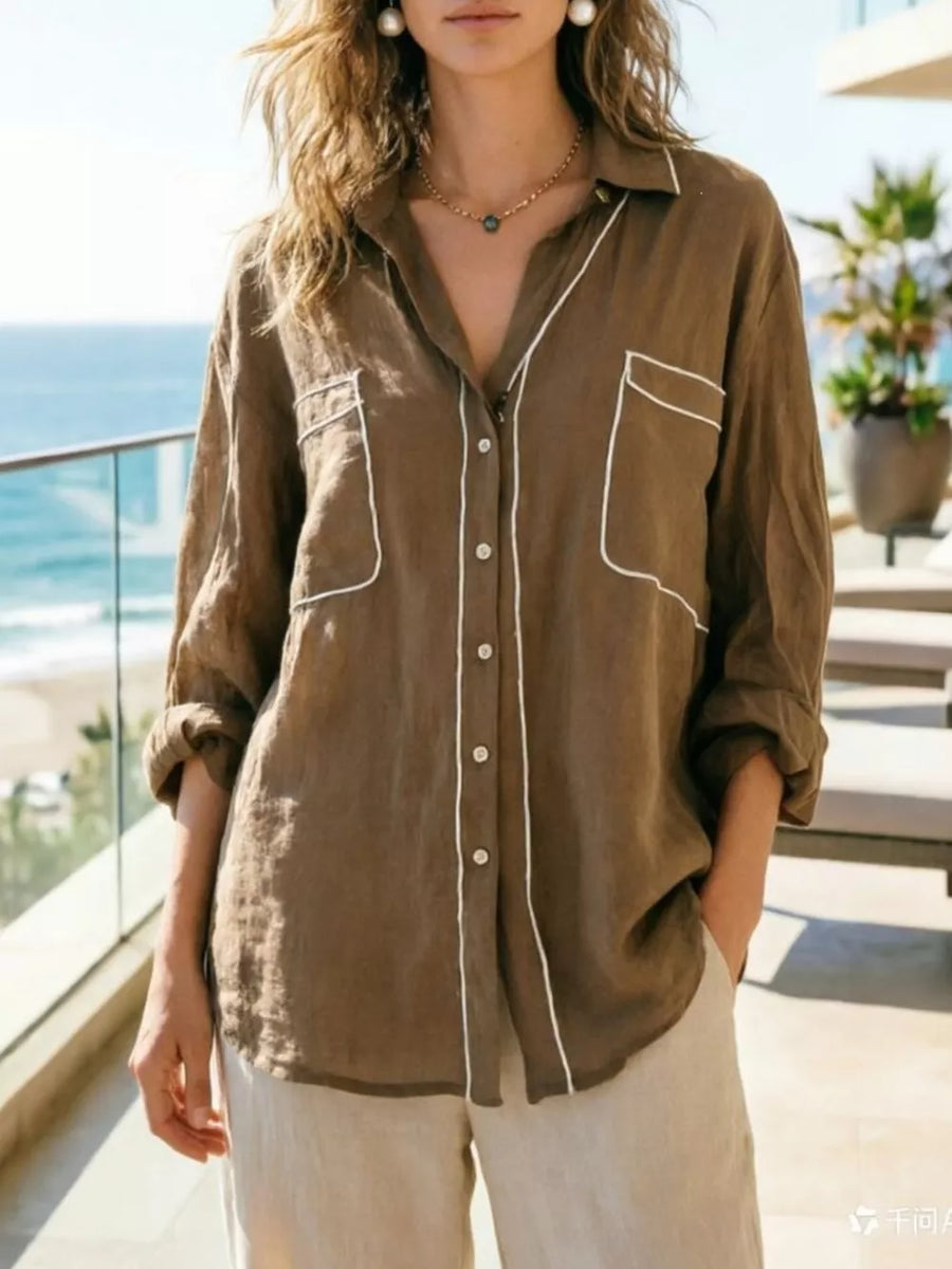 Brown linen shirt with white piping, button-down, long sleeves, and two chest pockets.