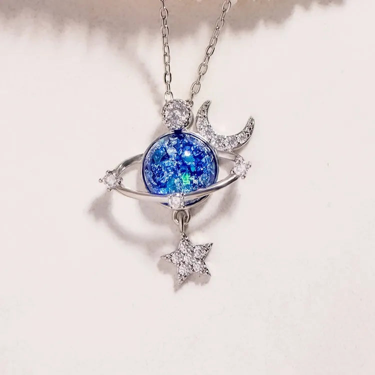 Silver celestial necklace with a cosmic orb, moon, and star charm.