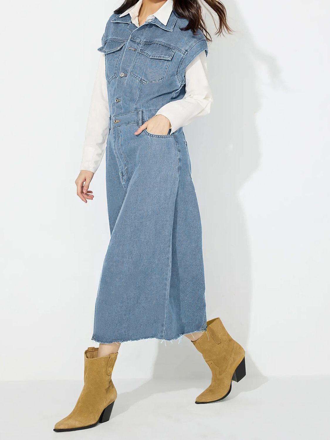 Sleeveless denim midi dress in light wash with button front, pockets, and slit.