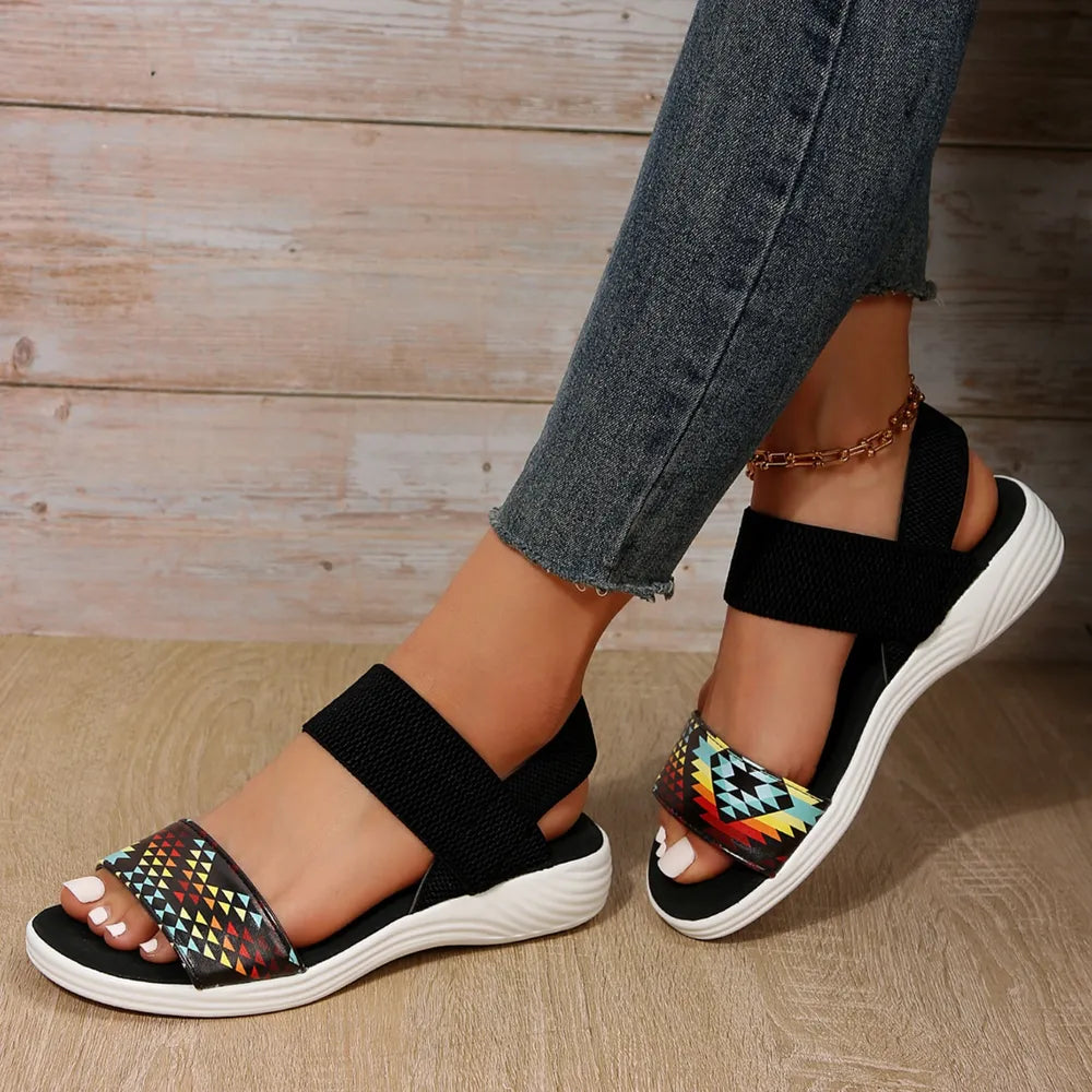 Geometric print elastic strap sandals with black elastic bands and white soles.