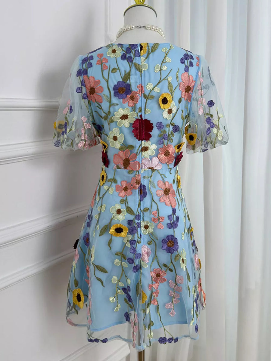 Blue floral embroidered mesh dress with short puff sleeves and a flared skirt.