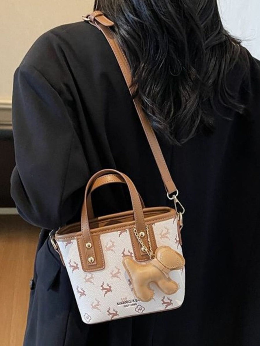 Charming mini crossbody bag with deer print and dog charm, tan trim