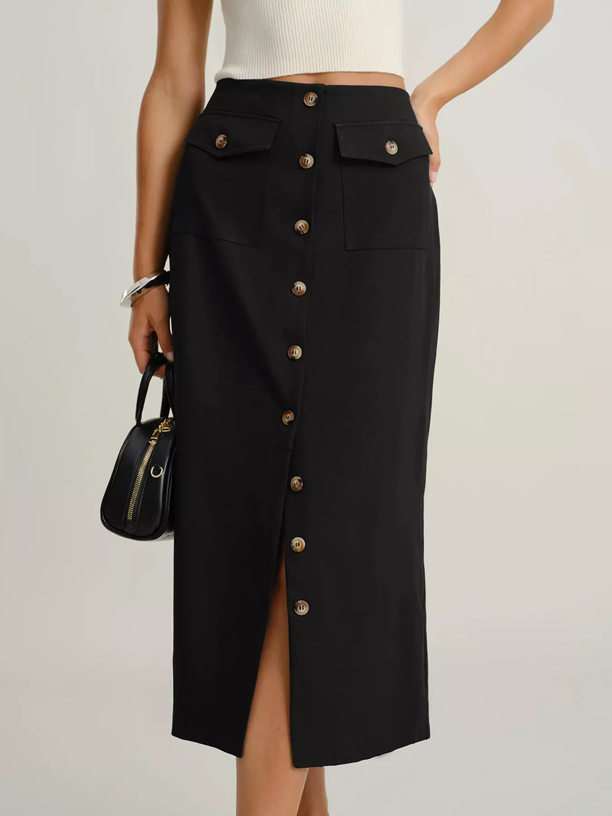 Black midi skirt with button front, patch pockets, and a side slit.