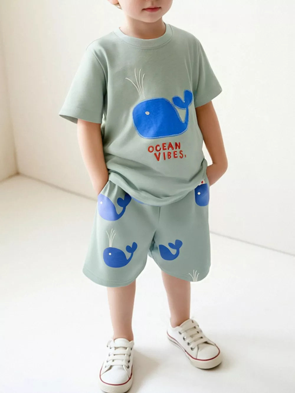 Toddler boys' light green cotton tee and shorts set with blue whale embroidery and print.